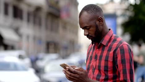 handsome-young-black-man-using-smartphone-in-the-street