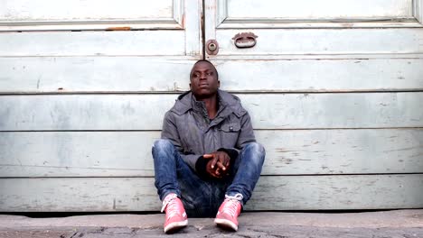 sad-pensive-black-African-immigrant-sitting-alone-in-the-ground