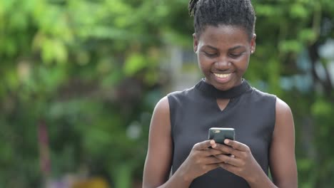 Joven-empresaria-africana-hermosa-con-teléfono-al-aire-libre