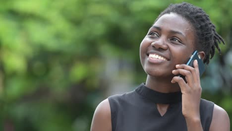 Young-beautiful-African-businesswoman-talking-on-the-phone-outdoors