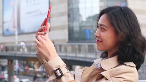 video-de-mujer-bastante-asiática-charlando-por-teléfono-en-la-ciudad