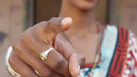 Close-up-of-beautiful-Indian-lady-in-traditional-dress-looks-and-points-at-camera-thumbs-up-best-of-luck-be-good-finger-leader-command-select-face-approves-hand-gesture-smiles-happy-focus-shift