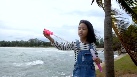 Slow-motion-Asian-little-girl-playing-bubble-balloon-nearly-the-beach