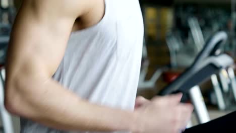 A-shirtless-guy-at-the-gym,-trains-his-body-to-stay-fit-and-have-defined-muscles.-The-athlete-raises-heavy-weights-and-fatigue.