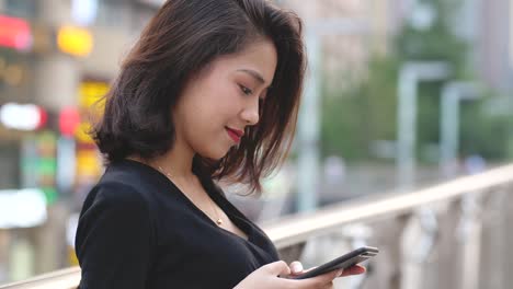 Young-woman-using-phone-in-street