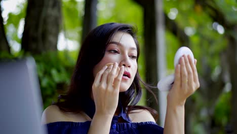 woman-applying-make-up-with-powder-puff