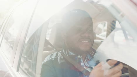 Guapo-negro-hombre-viajando-en-un-coche,-sentado-en-un-asiento-pasajero-usa-Smartphone-con-una-mano,-los-tipos-de-mensaje,-navega-a-través-de-Internet.-Cámara-de-disparo-desde-fuera-del-vehículo.