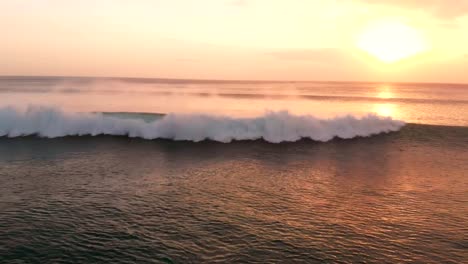 Vista-aérea-con-mar-y-olas-en-el-cálido-atardecer-en-Bali