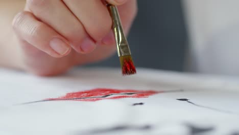 Artist-Dabbing-Red-Paint-on-Image-on-Fabric