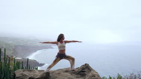 Mujer-joven-medita-en-la-cima-de-la-montaña