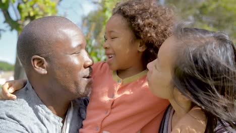 Hija-rizada-afro-americana-abrazándose-y-besándose-los-padres