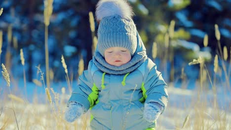 Glückliches-Kind-erhebt-sich-aus-einer-Schneewehe.-Gehen-und-sich-umsehen.-Wintertag.-Close-up