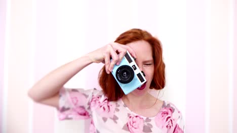 Mujer-joven-sonriente-con-vintage-cámara-en-la-mano