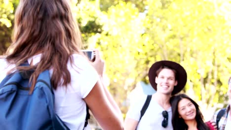 Smiling-woman-taking-picture-to-hipster-friends