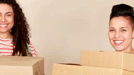 Smiling-lesbian-couple-moving-boxes