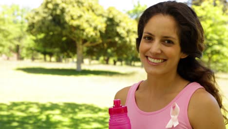 Happy-woman-wearing-pink-for-breast-cancer-awareness-drinking-water