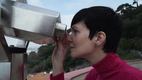 Frau-tourist-stehend-auf-Aussichtsplattform-durch-ein-Teleskop