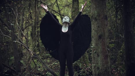 4k-Halloween-Dark-Angel-Frau-mit-schwarzen-Flügeln-in-Wald-Hands-up