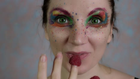 4k-Shot-of-a-Woman-with-Multicoloured-Make-up-Eating-Raspberry