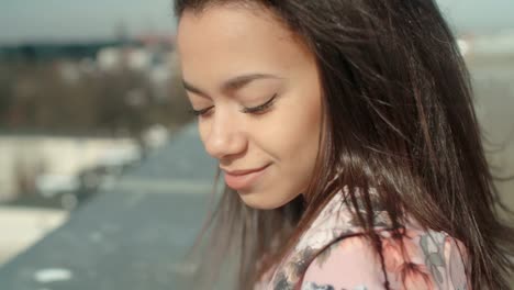 Young-beautiful-woman-enjoying-time-on-a-rooftop.