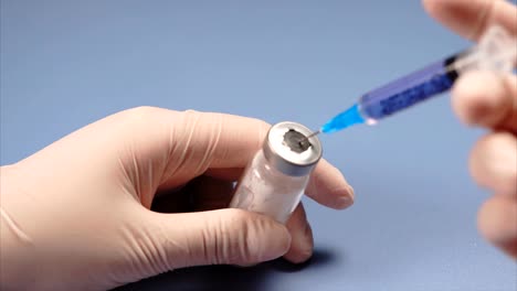 Doctor-piercing-the-lid-of-the-ampoule-with-syringe