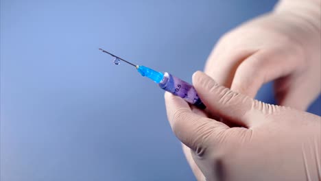 Syringe-in-doctor's-hands.-Medicine-leaking-from-a-syringe.