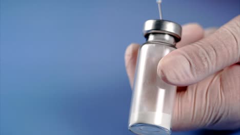 Doctor-piercing-the-lid-of-the-ampoule-with-syringe.