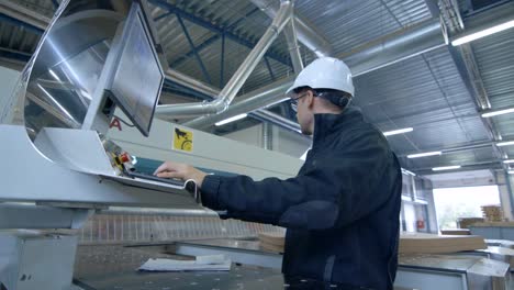 Engineer-Wearing-Hard-Hat-Setting-Up-CNC-Machine-at-the-Factory