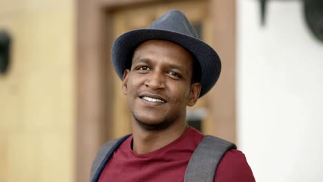 Portriat-of-happy-african-tourist-man-backpacker-smiling-and-looking-into-camera.-Mixed-race-young-guy-travelling-in-Europe