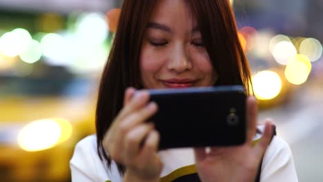 Handsome-Chinese-Woman-Texting-and-Talking-to-the-Phone-in-Public-Space.-Being-Happy,-Smiling-and-Having-Fun.