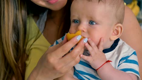 La-madre-alimenta-a-un-hijo-pequeño-con-un-albaricoque