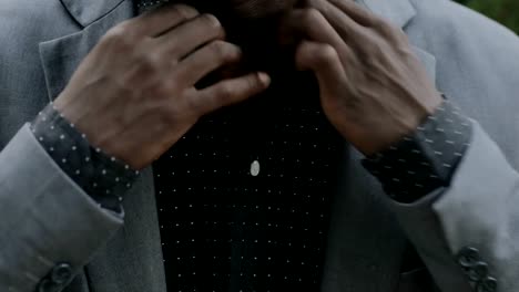 Closeup-portrait-of-young-african-postgraduate-student-in-classical-suit-buttoning-shirt