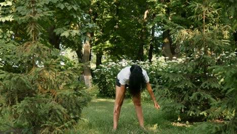 Charming-brunette-makes-sports-exercises-at-the-morning-in-park