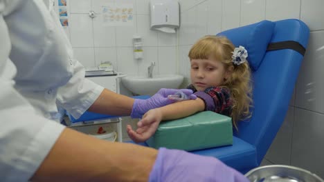 Nurse-is-taking-blood-sample-from-a-vein-in-the-arm-of-little-girl