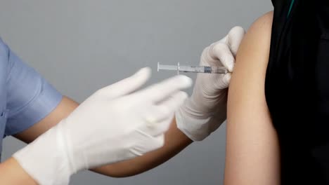 Doctor-injecting-flu-vaccine-to-patient's-arm