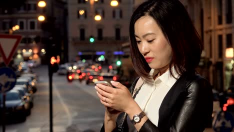 Asiatische-Geschäftsfrau-konzentrierte-sich-auf-das-Schreiben-auf-dem-Smartphone-Stadt-Nacht