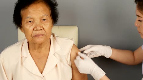 Doctor-injecting-flu-vaccine-to-patient's-arm-in-local-hospital