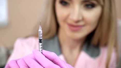 Doctor-in-a-dressing-gown-and-gloves,-preparing-an-injection-syringe.