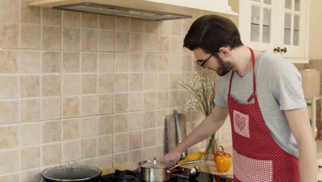 Young-guy-checks-the-soup-on-the-stove