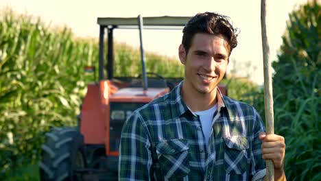 Retrato-de-un-feliz-joven-agricultor-con-verduras-en-una-canasta.-Fondo-de-una-ecología-tractor-y-naturaleza-concepto-biológico,-productos-bio,-bio,-cultivada-por-manos-propias,-vegetarianos,-ensaladas-saludable