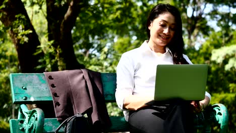 Asian-business-woman-relax-at-work-with-laptop-in-the-park.
