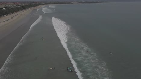 Aerial-view-waves-break-on-white-sand-beach.-Video.-Sea-waves-on-the-beautiful-beach-aerial-view.-People-in-water