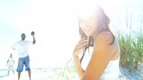 Portrait-of-young-ethnic-mum-sitting-on-beach