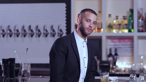 Portrait-shot-of-a-young-attractive-African-American-man-staring-blankly-at-the-camera-at-a-bar