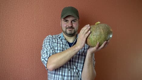 A-man-in-a-cap-holding-a-pumpkin