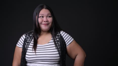 Beautiful-overweight-Asian-woman-against-black-background