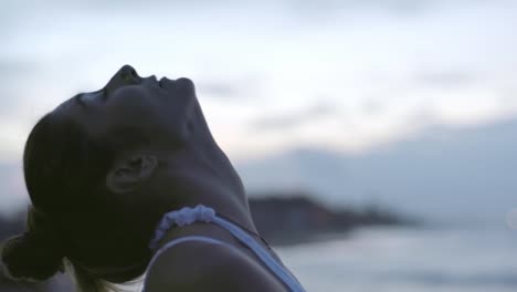 Mujer-que-se-extiende-en-la-playa-por-la-mañana