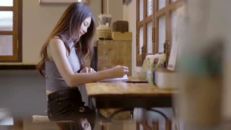 Asiatische-Frauen-lesen-Bücher-mit-heißem-Kaffee-in-Cafés.