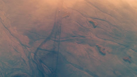 Jeeps-moving-below-think-mist-in-Mount-Bromo-an-aerial-view,-Indonesia