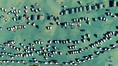 Vista-aérea-de-Jeeps-a-la-espera-de-turistas-en-el-estacionamiento-en-Monte-Bromo,-Indonesia